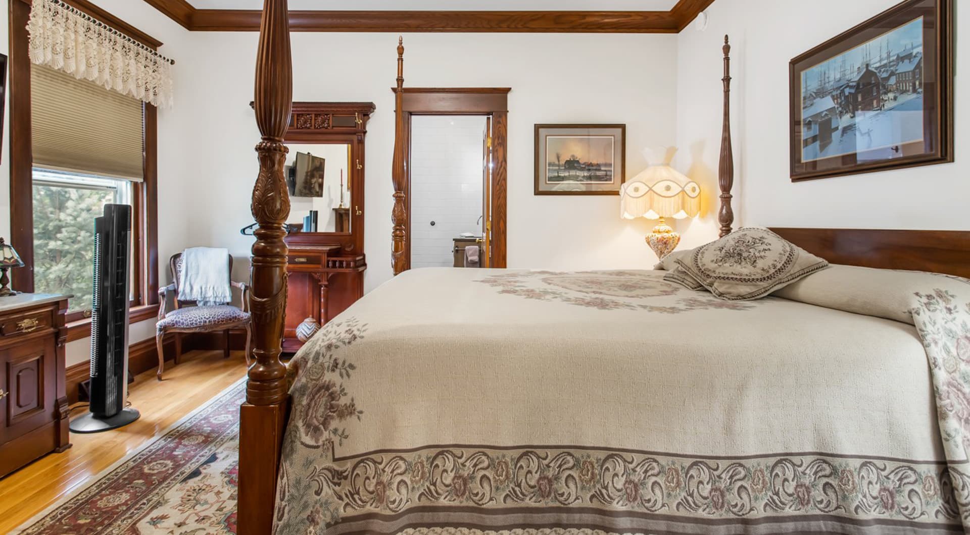 A cozy bedroom featuring a four-poster bed, vintage decor, and a warm color palette.