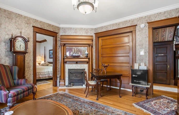Vintage living room featuring a decorative fireplace, a striped armchair, and wooden accents.