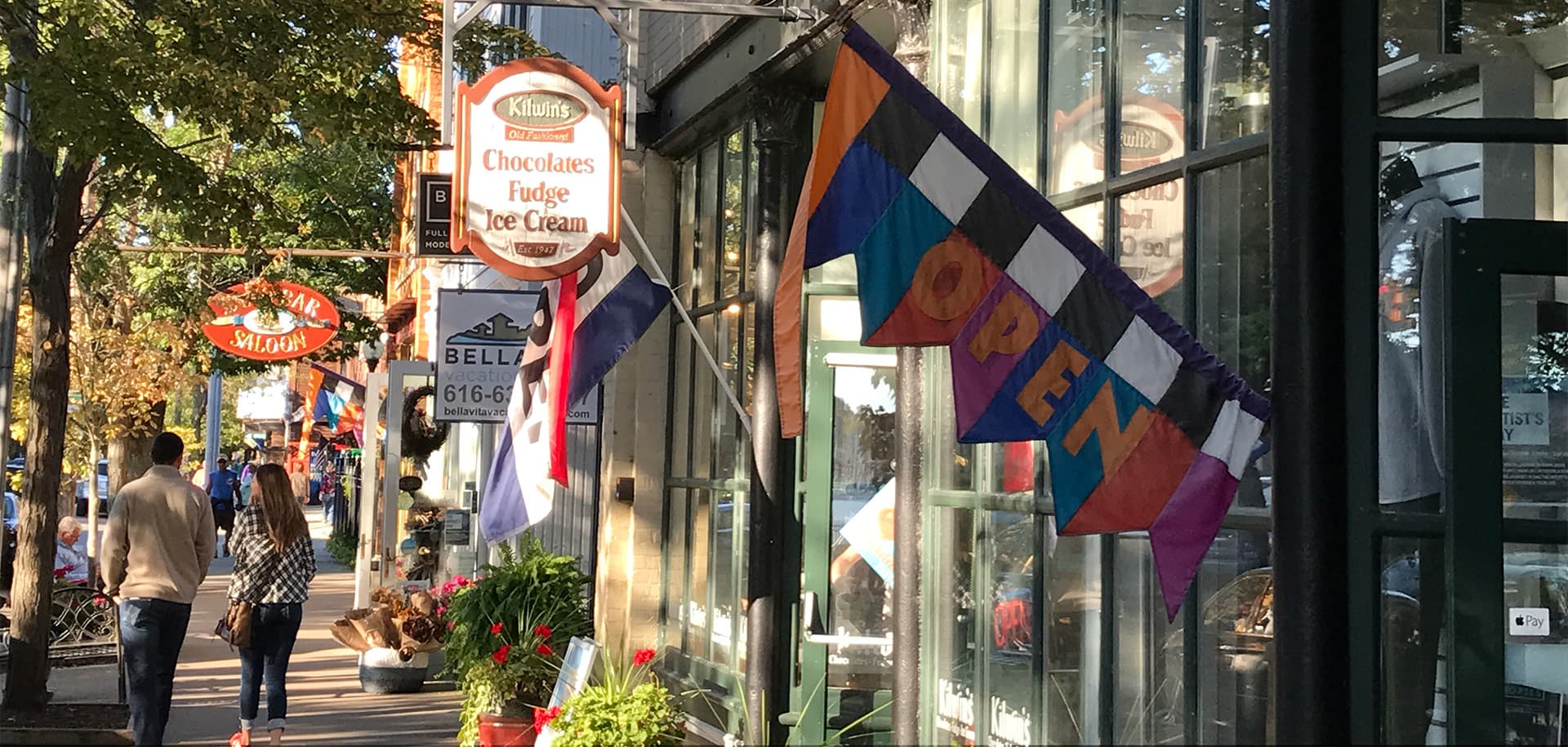 A bustling street scene with shops, featuring a prominent "OPEN" banner and colorful storefronts.
